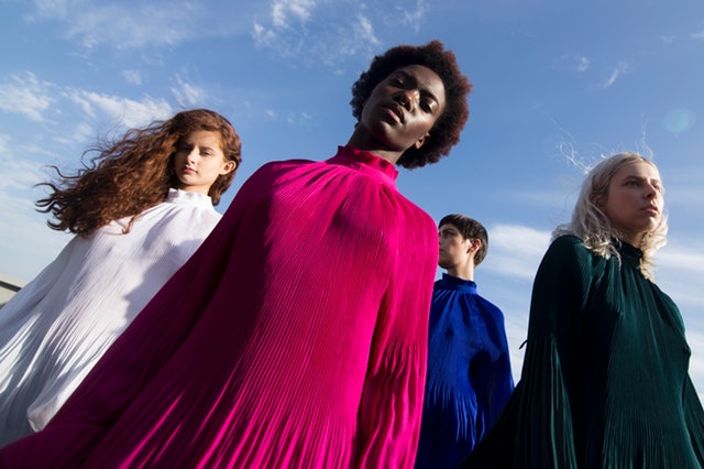 Skupina žien v bielych, modrých, zelených a ružových šatách